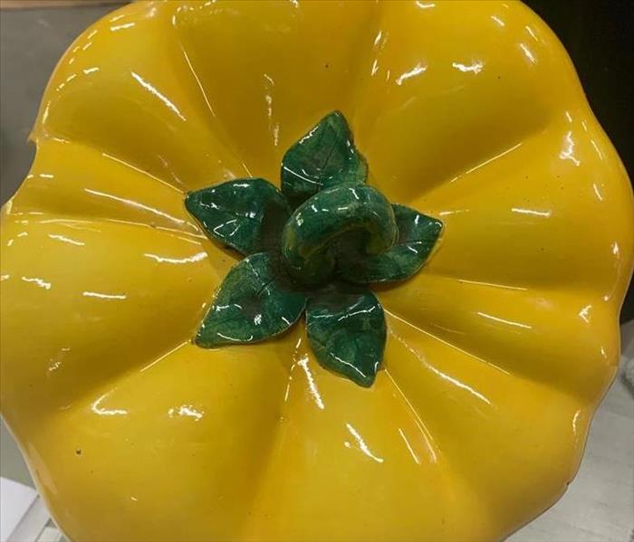 A clean and shiny ceramic yellow bell pepper lid